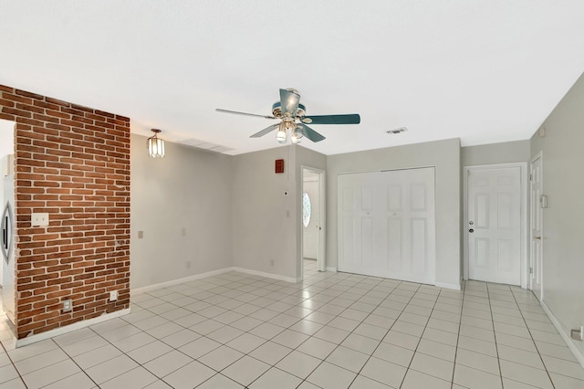 1746 W Terrace Dr, Lake Worth, FL 33460 - empty room with a ceiling fan, brick wall, baseboards, and light tile patterned floors