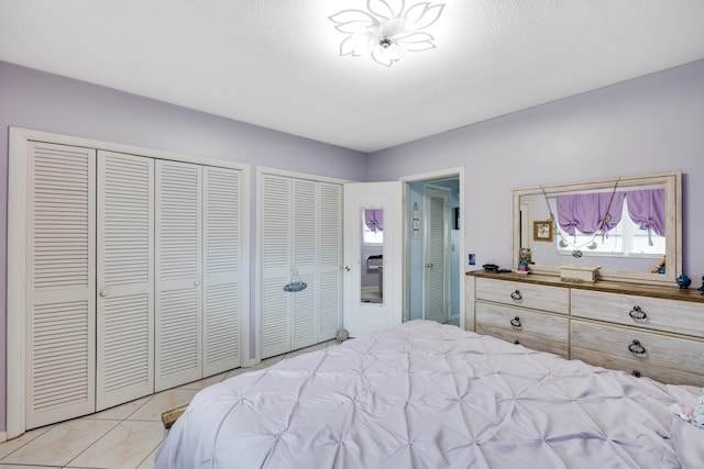bedroom featuring two closets and marble finish floor