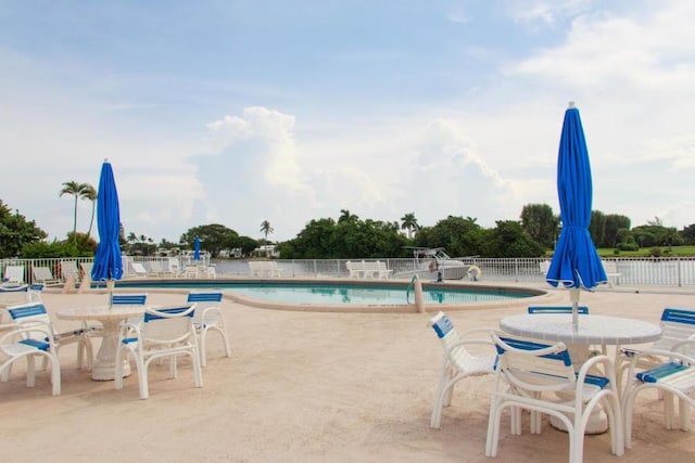 community pool featuring fence and a patio area