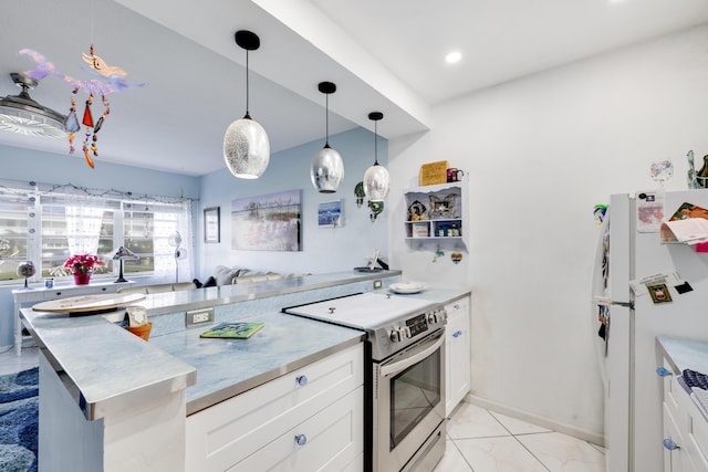 kitchen with electric stove, pendant lighting, light countertops, white cabinetry, and freestanding refrigerator