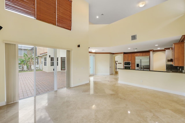 9682 Campi Dr, Lake Worth, FL 33467 - unfurnished living room featuring visible vents, baseboards, arched walkways, a high ceiling, and recessed lighting