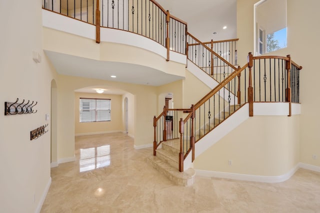 9682 Campi Dr, Lake Worth, FL 33467 - stairs featuring arched walkways, a towering ceiling, baseboards, and a wealth of natural light