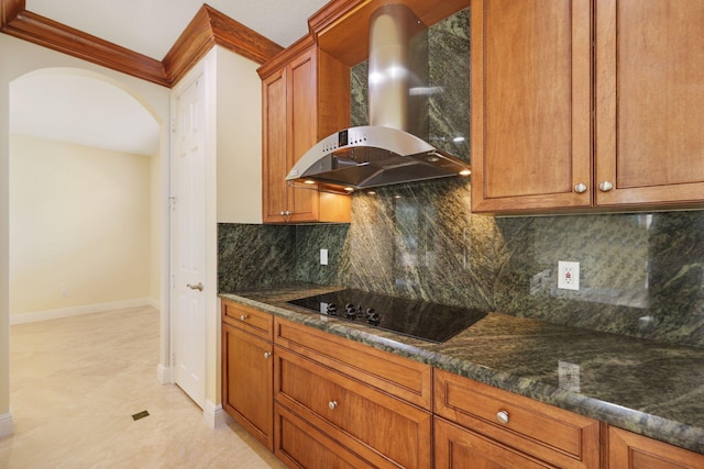 9682 Campi Dr, Lake Worth, FL 33467 - kitchen featuring arched walkways, wall chimney exhaust hood, brown cabinets, black electric stovetop, and backsplash