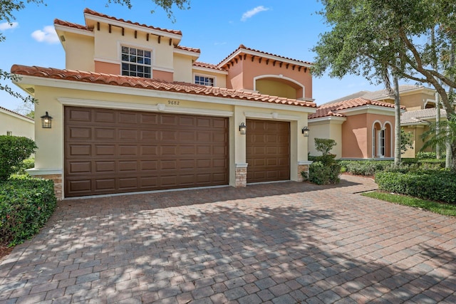 9682 Campi Dr, Lake Worth, FL 33467 - mediterranean / spanish house with a tiled roof, a garage, stucco siding, and decorative driveway