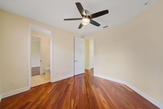 9682 Campi Dr, Lake Worth, FL 33467 - unfurnished bedroom with baseboards, ensuite bathroom, visible vents, ceiling fan, and wood finished floors