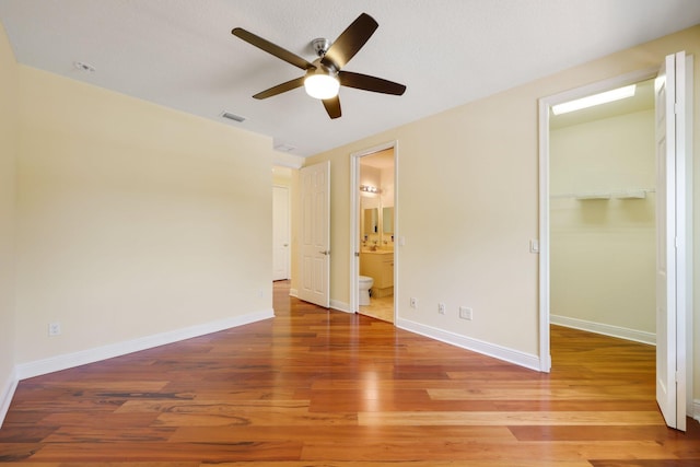 9682 Campi Dr, Lake Worth, FL 33467 - unfurnished bedroom with visible vents, a closet, baseboards, a spacious closet, and wood finished floors