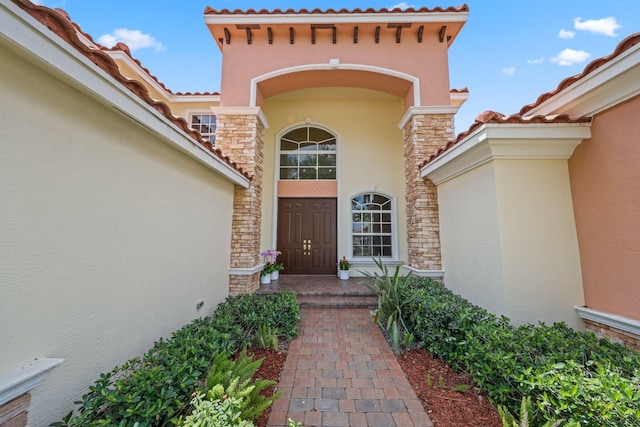 9682 Campi Dr, Lake Worth, FL 33467 - entrance to property featuring a tiled roof, stucco siding, and stone siding