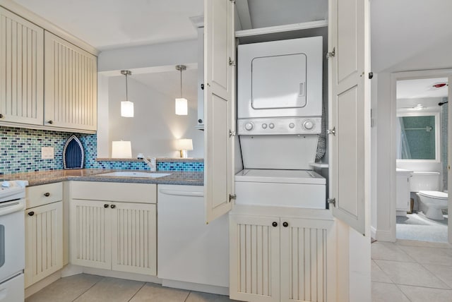 2809 Florida Blvd Unit 307, Delray Beach, FL 33483 - washroom with laundry area, stacked washer and dryer, light tile patterned floors, and a sink