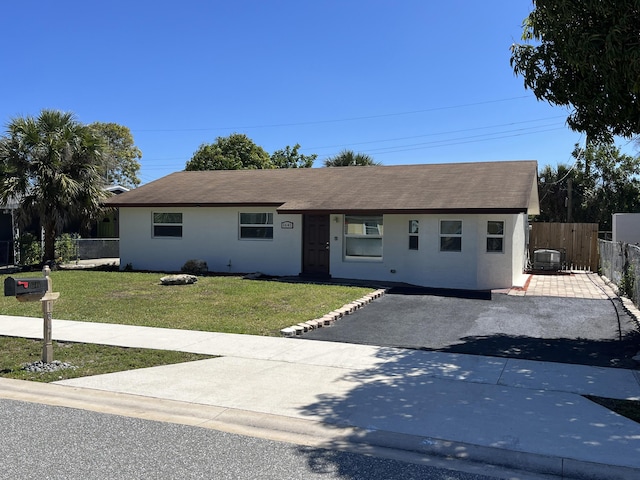 single story home featuring stucco siding, fence, a front lawn, and roof with shingles