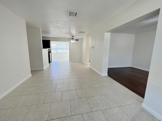 unfurnished room with baseboards, visible vents, ceiling fan, and light tile patterned floors