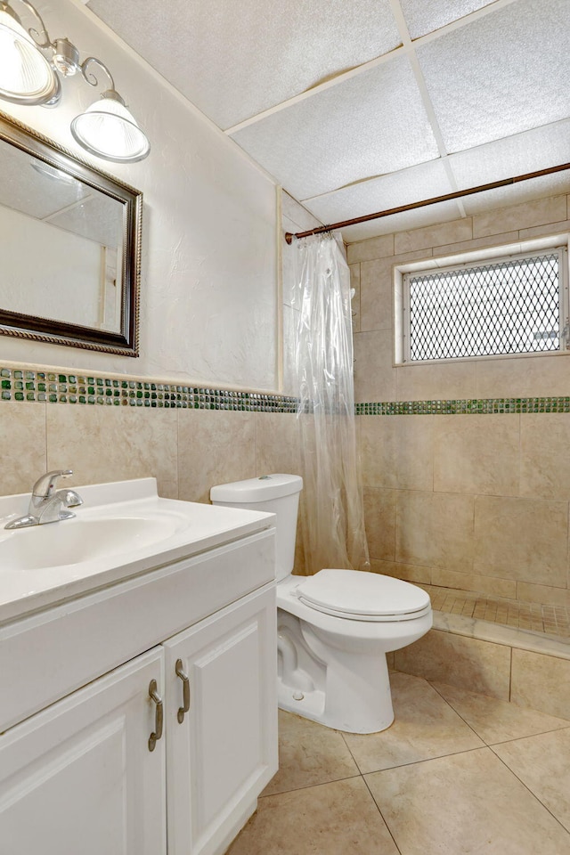 1021 Crystal Lake Dr Unit 109, Deerfield Beach, FL 33064 - bathroom with vanity, a tile shower, tile walls, toilet, and tile patterned floors