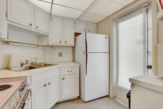 1021 Crystal Lake Dr Unit 109, Deerfield Beach, FL 33064 - kitchen featuring light countertops, range, light tile patterned flooring, freestanding refrigerator, and a paneled ceiling
