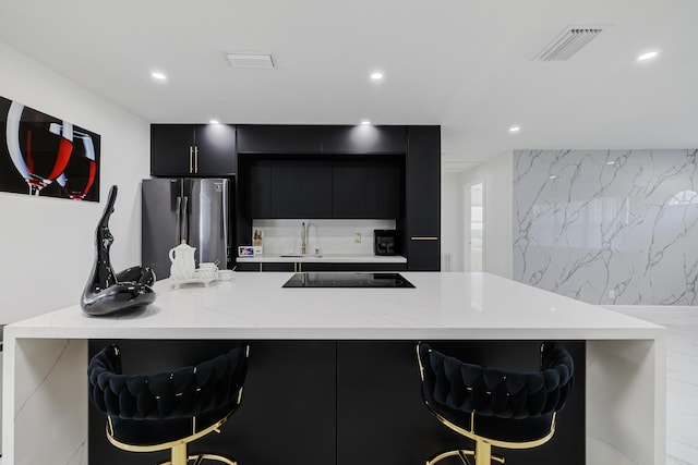 180 NW 18th St, Pompano Beach, FL 33060 - kitchen with freestanding refrigerator, visible vents, a sink, dark cabinetry, and black electric cooktop