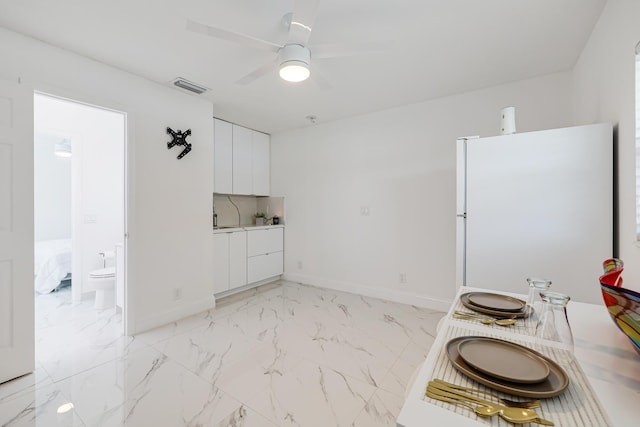 180 NW 18th St, Pompano Beach, FL 33060 - kitchen featuring freestanding refrigerator, white cabinets, visible vents, ceiling fan, and marble finish floor