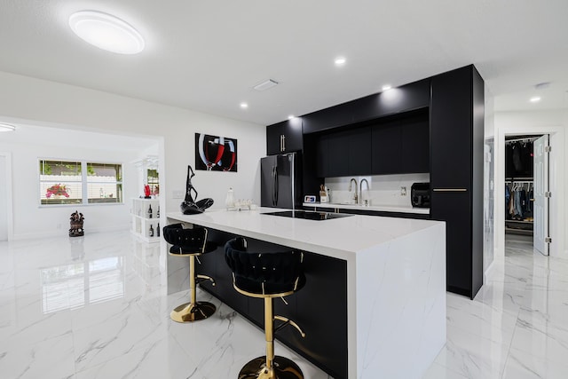 180 NW 18th St, Pompano Beach, FL 33060 - kitchen with a sink, modern cabinets, dark cabinetry, marble finish floor, and black appliances