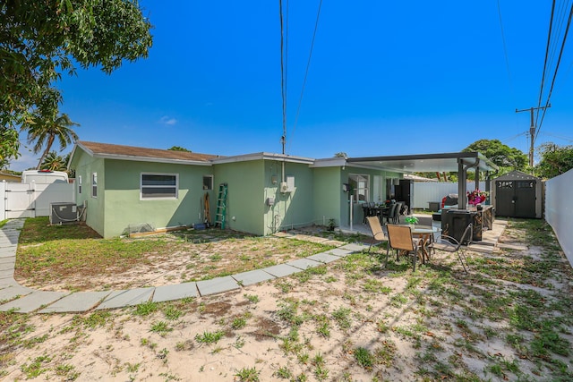 180 NW 18th St, Pompano Beach, FL 33060 - rear view of house with a storage shed, a fenced backyard, stucco siding, and an outdoor structure