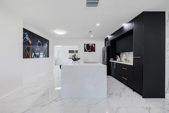 180 NW 18th St, Pompano Beach, FL 33060 - kitchen featuring a kitchen island, visible vents, modern cabinets, dark cabinetry, and a sink