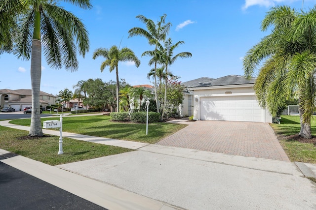 12761 Yardley Dr, Boca Raton, FL 33428 - view of front of home with an attached garage, a front yard, stucco siding, and decorative driveway