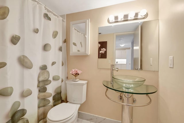 1502 S Lakeside Dr Unit 318, Lake Worth, FL 33460 - full bathroom with a sink, toilet, a shower with shower curtain, and baseboards