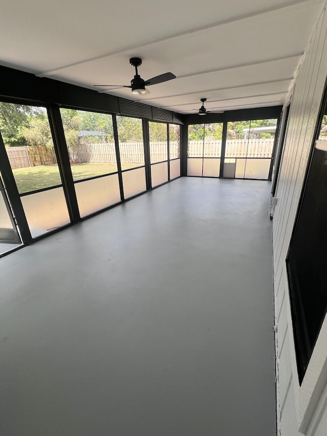 unfurnished sunroom featuring ceiling fan and a wealth of natural light