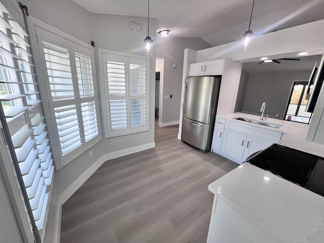 kitchen featuring decorative light fixtures, ceiling fan, a sink, and freestanding refrigerator