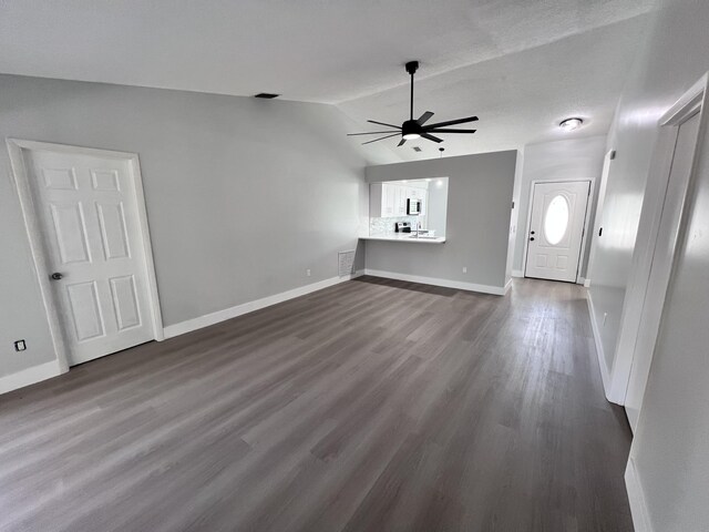 unfurnished living room with lofted ceiling, baseboards, visible vents, ceiling fan, and dark wood-type flooring
