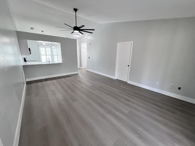 unfurnished living room with baseboards, lofted ceiling, ceiling fan, and dark wood finished floors