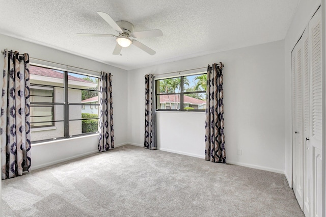 9805 Walnut Tree A Way Unit A, Boynton Beach, FL 33436 - unfurnished bedroom featuring a ceiling fan, a textured ceiling, a closet, baseboards, and carpet flooring