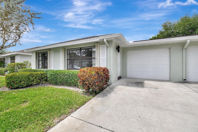 9805 Walnut Tree A Way Unit A, Boynton Beach, FL 33436 - view of front of house featuring a garage, driveway, a front yard, and stucco siding