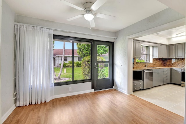 9805 Walnut Tree A Way Unit A, Boynton Beach, FL 33436 - kitchen with stainless steel appliances, a sink, light wood-type flooring, baseboards, and ceiling fan