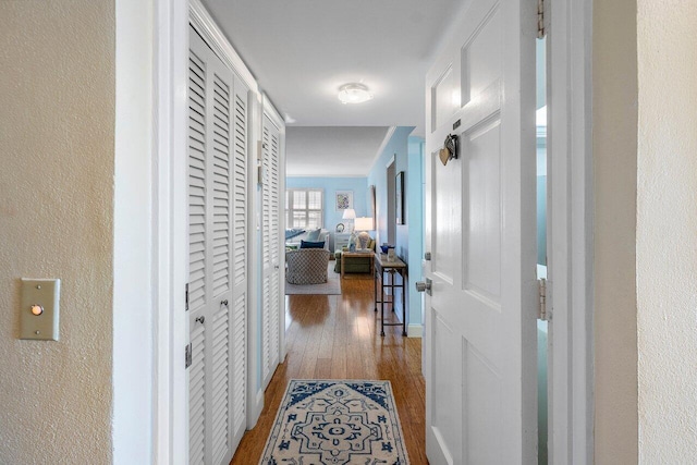 hallway featuring a textured wall and wood finished floors