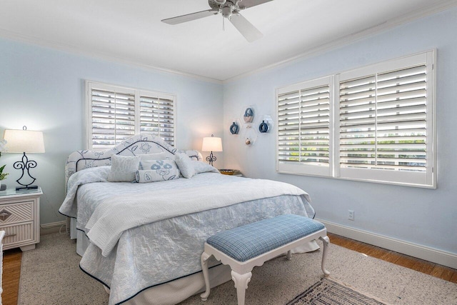 bedroom featuring baseboards, ornamental molding, wood finished floors, and a ceiling fan