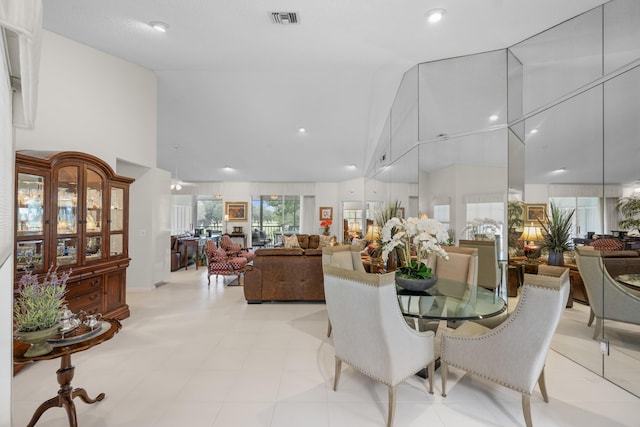 dining area with high vaulted ceiling and visible vents