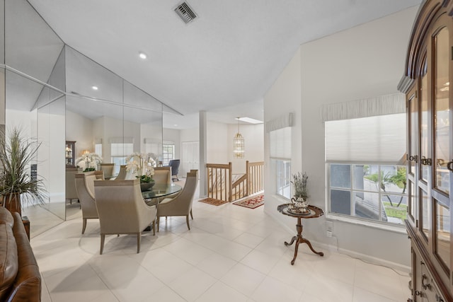 tiled dining space with visible vents, recessed lighting, baseboards, and high vaulted ceiling