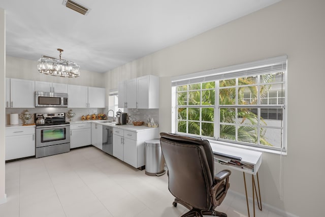 kitchen featuring visible vents, light countertops, white cabinets, a sink, and appliances with stainless steel finishes