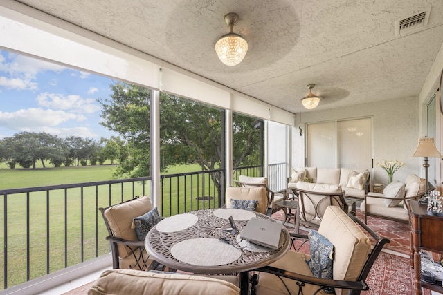 sunroom with visible vents, an outdoor living space, and a wealth of natural light