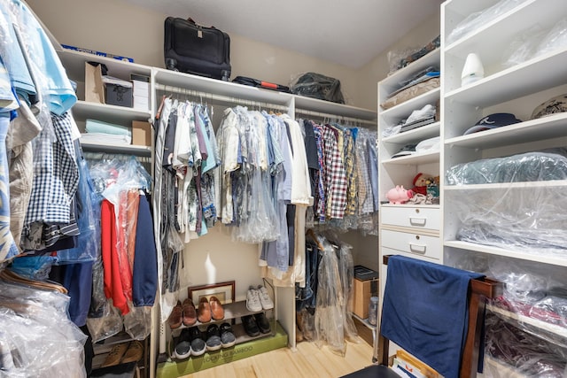 walk in closet with wood finished floors
