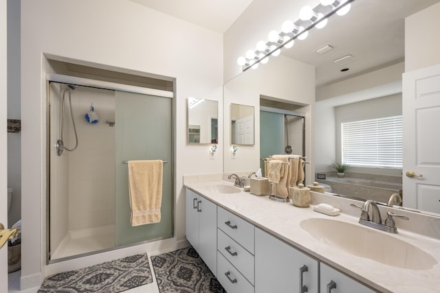 bathroom with double vanity, tile patterned floors, a sink, and a stall shower