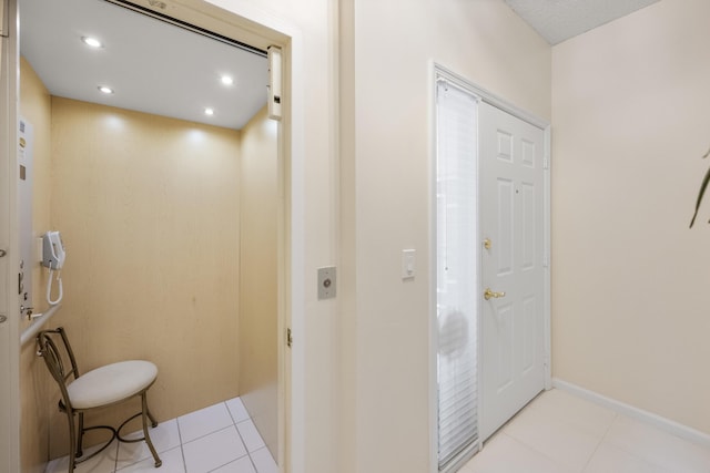 hallway featuring recessed lighting, tile patterned flooring, and elevator