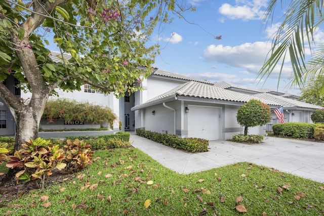 view of home's exterior with a tiled roof, a garage, driveway, and stucco siding