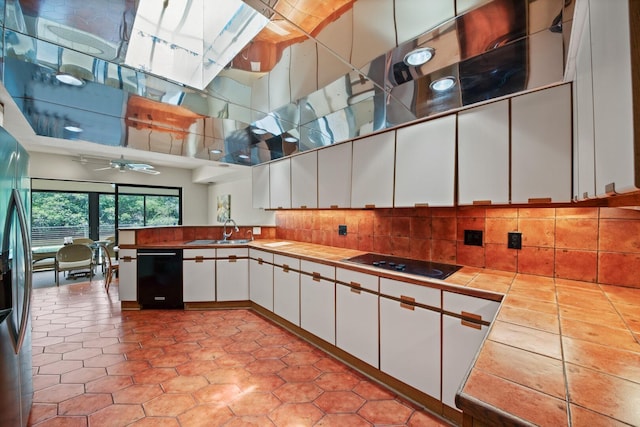 7 Inlet Cay Dr, Ocean Ridge, FL 33435 - kitchen with a sink, a towering ceiling, tile countertops, black appliances, and white cabinetry