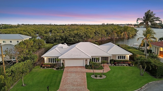 7 Inlet Cay Dr, Ocean Ridge, FL 33435 - single story home with concrete driveway, a garage, a tiled roof, a front lawn, and a water view