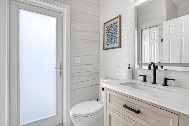 8086 Bautista Way, Palm Beach Gardens, FL 33418 - bathroom with a healthy amount of sunlight, tile walls, vanity, and toilet