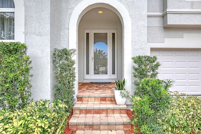 8086 Bautista Way, Palm Beach Gardens, FL 33418 - view of exterior entry with a garage and stucco siding