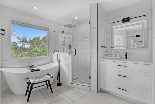 8086 Bautista Way, Palm Beach Gardens, FL 33418 - bathroom with vanity, marble finish floor, a freestanding tub, tile walls, and a marble finish shower