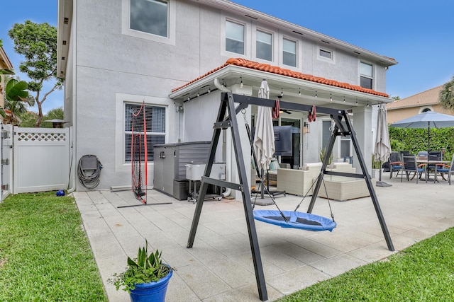 8086 Bautista Way, Palm Beach Gardens, FL 33418 - rear view of property with fence, stucco siding, an outdoor hangout area, a gate, and a patio area
