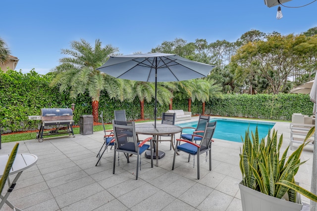 8086 Bautista Way, Palm Beach Gardens, FL 33418 - view of patio with a fenced in pool, a fenced backyard, outdoor dining space, and area for grilling