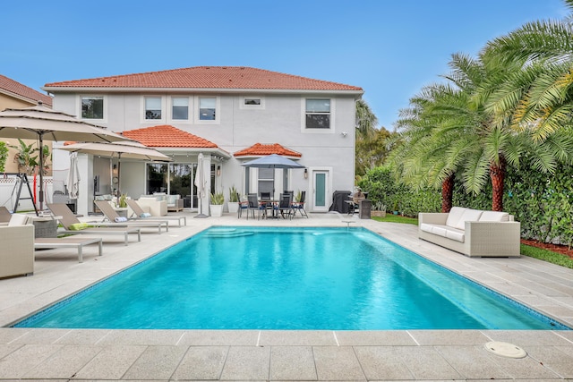 8086 Bautista Way, Palm Beach Gardens, FL 33418 - back of house featuring stucco siding, a patio area, an outdoor pool, and a tiled roof