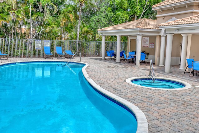8086 Bautista Way, Palm Beach Gardens, FL 33418 - community pool featuring a hot tub, fence, outdoor dining area, and a patio area