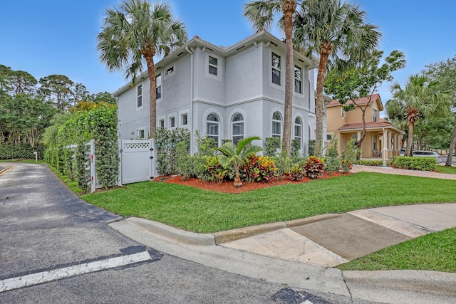 8086 Bautista Way, Palm Beach Gardens, FL 33418 - view of front of house featuring stucco siding, fence, a gate, and a front lawn